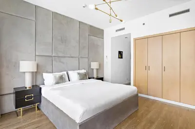 a bedroom with a large bed and two lamps at VayK - Exquisite 2BR with Panoramic Marina View in Dubai