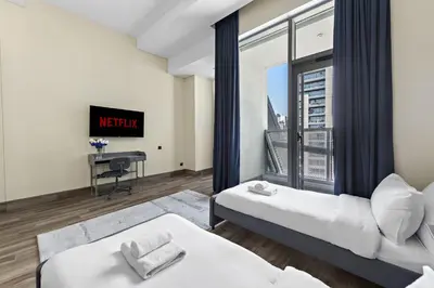 a bedroom with two beds and a window with a view at Vayk - Spacious and Vibrant 2BR Apartment in Business Bay in Dubai