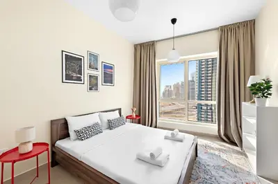 a bedroom with a bed and a large window at VayK - Welcoming and Warm 2BR in JLT in Dubai