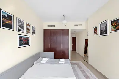 a bedroom with a bed and pictures on the wall at VayK - Welcoming and Warm 2BR in JLT in Dubai