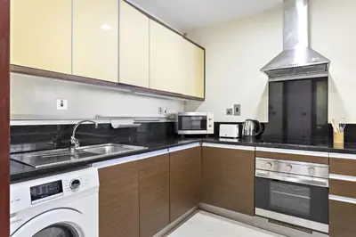 a kitchen with a washer and a sink and a stove at VayK - Stylish 1BR in Palm Jumeirah with Secluded Beach Access in Dubai