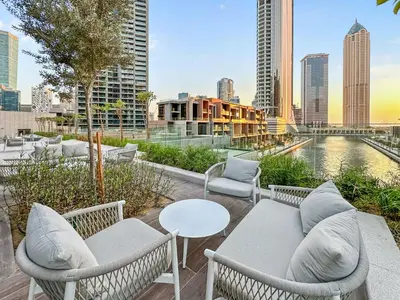 a patio with chairs and tables and a view of a city at Elevated 2 Bedroom with Khalifa view in Peninsula in Dubai