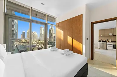 a bedroom with a large white bed and a large window at VayK - Chic Marina-Front 1BR in a Luxurious Location in Dubai