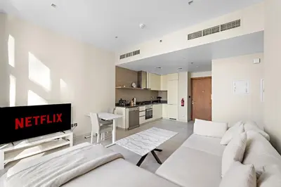 a living room with a couch and a tv at VayK - Chic Marina-Front 1BR in a Luxurious Location in Dubai