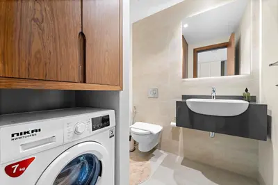 a bathroom with a washing machine and a sink at VayK - Chic Marina-Front 1BR in a Luxurious Location in Dubai