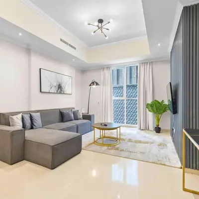 a living room with a couch and a table at Heart of Downtown Luxury 1BHK Dunya in Dubai