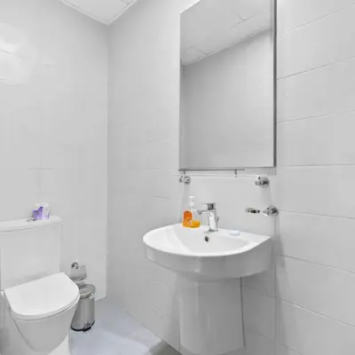 a white bathroom with a toilet and a sink at Heart of Downtown Luxury 1BHK Dunya in Dubai