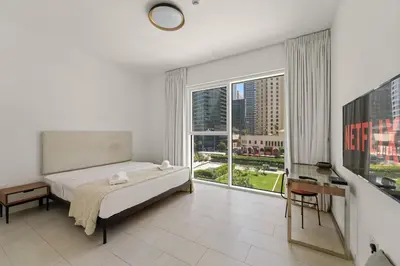 a bedroom with a bed and a large window at VayK - Feel the Festive Vibe in Cozy 1BR with Beach Access in Dubai