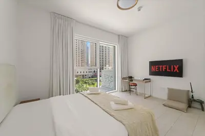 a bedroom with a large white bed and a window at VayK - Feel the Festive Vibe in Cozy 1BR with Beach Access in Dubai
