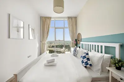 a white couch in a room with a large window at VayK - Bright and Stylish 1BR in Marina in Dubai