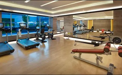 a gym with cardio equipment in a hotel room at Stylish Stay at DAMAC Maison Cour Jardin Canalview in Dubai