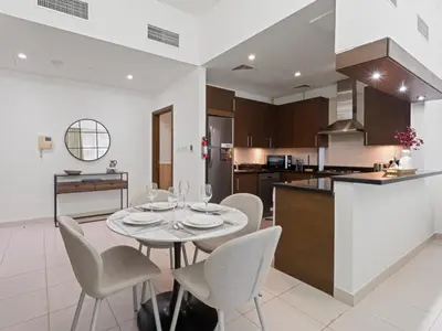 a kitchen and dining room with a table and chairs at Dreamy Haven Studio in West Wharf in Dubai
