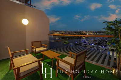 a balcony with tables and chairs and a view of a harbor at LUX The Palm Sea View Studio in Dubai