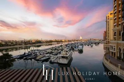 a group of boats docked in a marina at sunset at LUX The Palm Sea View Studio in Dubai