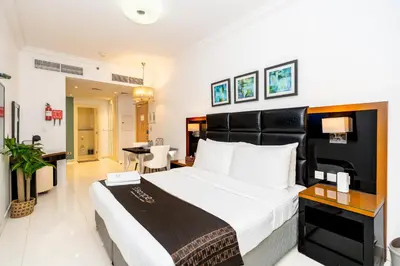 a bedroom with a large bed and a living room at Escape24 Cozy Studio at Capital Bay near Burj Khalifa in Dubai