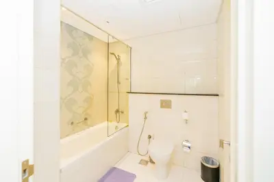 a bathroom with a toilet and a tub and a sink at Escape24 Cozy Studio at Capital Bay near Burj Khalifa in Dubai