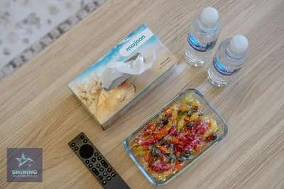 a table with a bowl of food and two bottles of water at Luxury Spacious 1BR JVC 2Bath Pool Gym in Dubai