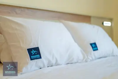 a bed with white pillows with signs on it at Luxury Spacious 1BR JVC 2Bath Pool Gym in Dubai