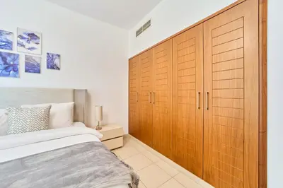 a bedroom with a large wooden closet and a bed at Golden Homes Aqua Bay 1BR-BLVD CENTRAL Downtown Dubai mall in Dubai
