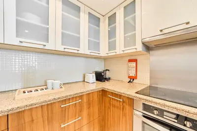 a kitchen with wooden cabinets and a counter top at Golden Homes Aqua Bay 1BR-BLVD CENTRAL Downtown Dubai mall in Dubai