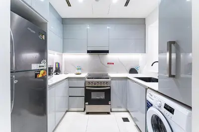 a white kitchen with a stove and a dishwasher at HAVN- 1 Bedroom in Binghatti, Al Jaddaf in Dubai