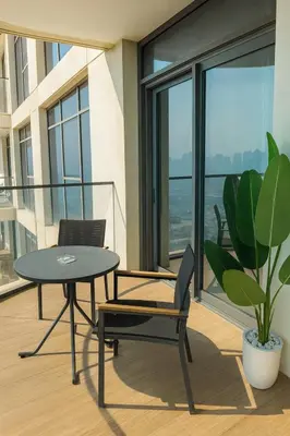 a balcony with a table and a chair and a plant at Marina Vista 2BR High Floor Sea View Emaar Beachfront in Dubai