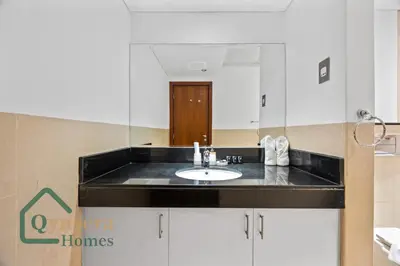 a bathroom with a sink and a large mirror at Skyline Bliss Luxury Apartment Dubai in Dubai