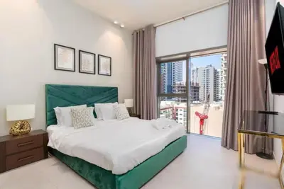 a bedroom with a large bed and a large window at Fully furnished studio with amenities in Dubai in Dubai