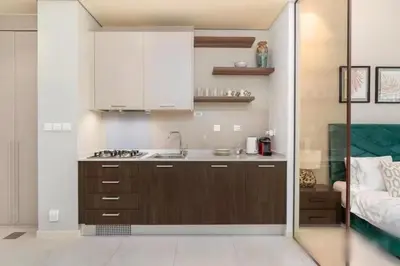 a kitchen with brown cabinets and a sink at Fully furnished studio with amenities in Dubai in Dubai