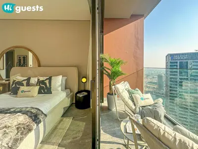 a bedroom with a bed and a balcony with a view at HiGuests - High Rise Studio Haven in Business Bay in Dubai