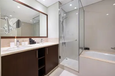 a bathroom with a shower and a sink and a tub at Spacious Lux 4 Bed with Large Balcony and Burj View by Vista Stays Dubai in Dubai