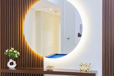a bathroom with a round mirror on a wall at Spacious Lux 4 Bed with Large Balcony and Burj View by Vista Stays Dubai in Dubai