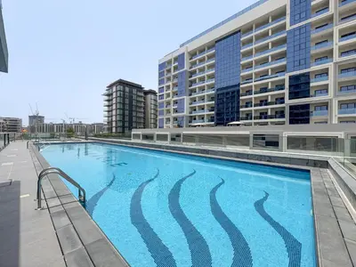 a large swimming pool in front of a building at Vogue Dubai Hills The Pinnacle near Dubai Hills Mall and Park, One Bedroom Apartment with Large Balcony and City View, Access to all Amenities in Dubai