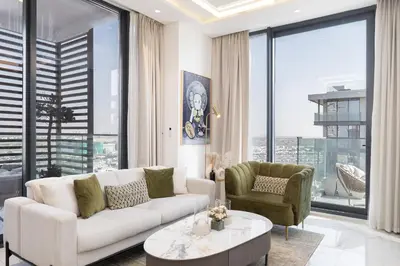 a living room with a couch and a table and chairs at Vogue Dubai Hills The Pinnacle near Dubai Hills Mall and Park, One Bedroom Apartment with Large Balcony and City View, Access to all Amenities in Dubai
