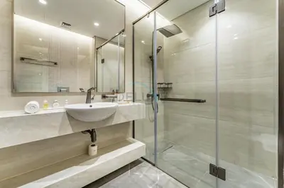 a bathroom with a sink and a glass shower at Sky-High 2BR with City Views, Minutes Drive to Downtown, Steps from the Bus Stop, Nobles Tower, Business Bay by Deluxe Holiday Homes in Dubai