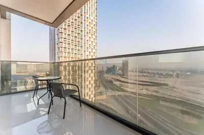 a balcony with a table and chairs in a building at Sky-High 2BR with City Views, Minutes Drive to Downtown, Steps from the Bus Stop, Nobles Tower, Business Bay by Deluxe Holiday Homes in Dubai