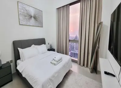 a bedroom with a white bed and a large window at Grande-5703,2 BHK Down Town, Dubai in Dubai