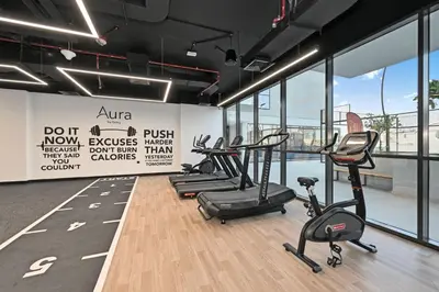 a gym with treadmills and elliptical machines at Aura by Grovy Studio - Parking, Sauna&Gym, Pool - by Rentujemy in Dubai