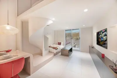 a living room with a staircase leading to a bedroom at Stylish Studio Loft with Outdoor Patio in JVC in Dubai