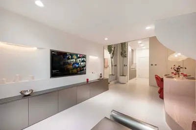 a living room with a tv on the wall at Stylish Studio Loft with Outdoor Patio in JVC in Dubai