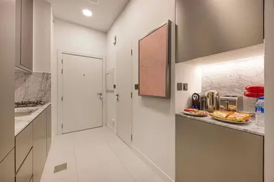 a kitchen with white cabinets and a counter top at Stylish Studio Loft with Outdoor Patio in JVC in Dubai