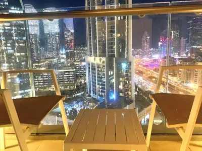 a view of a city at night from a window at Kempinski Central Avenue Residence Largest 1BR with Burj Khalifa View in Dubai