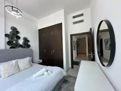 a bedroom with a white bed and a mirror at Modern 2 Bedroom Apartment in Dubai Marina in Dubai