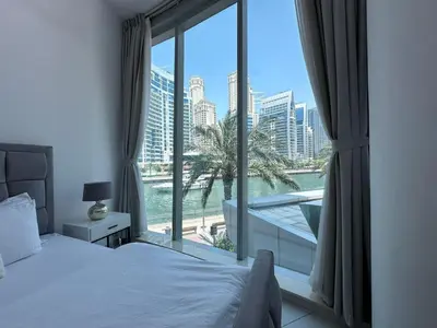 a bedroom with a large window with a view of a city at Modern 2 Bedroom Apartment in Dubai Marina in Dubai
