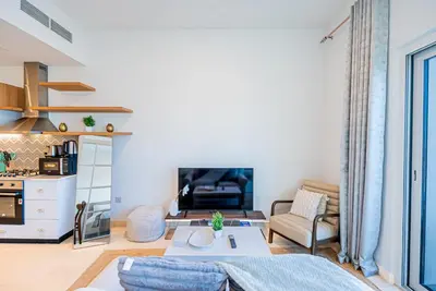 a living room with a couch and a table at Escape24 Contemporary 1BR with City Views in Dubai Hills in Dubai