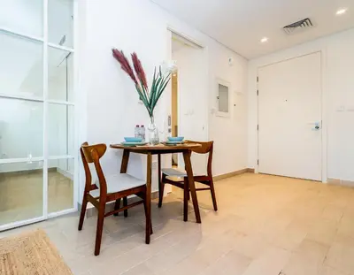 a dining room with a table and two chairs at Escape24 Contemporary 1BR with City Views in Dubai Hills in Dubai
