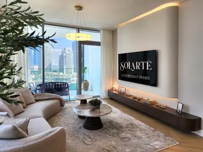 a living room with a couch and a tv at SOLARTE Luxe - LIV Marina - Premium 2BR Residence in Dubai