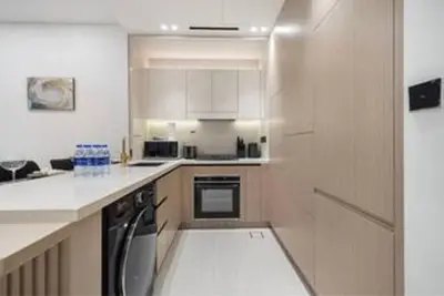 a kitchen with white cabinets and a white counter top at Elegant 2BR With Modern Design Near to Circle Mall in Dubai