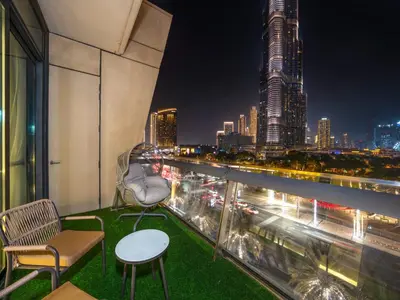 a balcony with a view of a city at night at Stunning 4BR Burj View Pool &Gym in Dubai