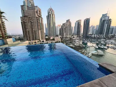 a large swimming pool with a view of a city at Free Infiniti Pool and Jacuzzi - Marina Gate Luxury Stay - Enjoy Dubai Marina Views in Dubai